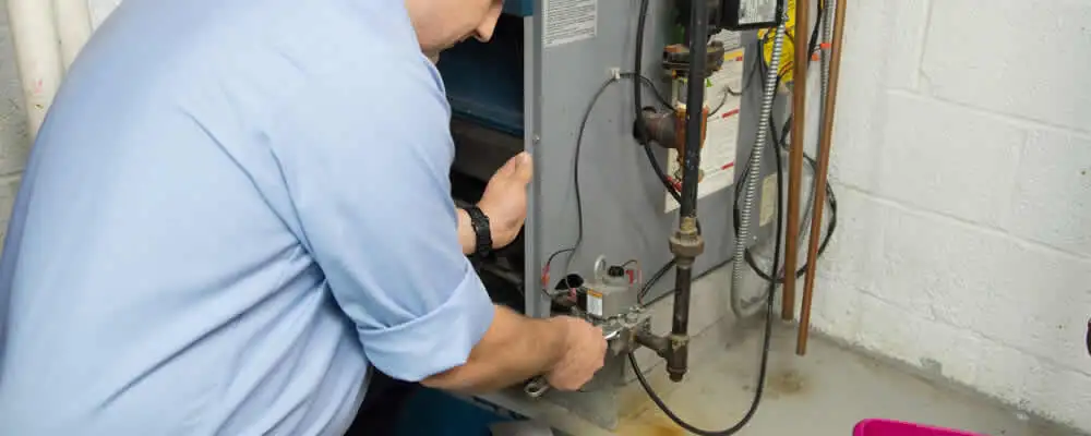 Furnace repair technician inspecting and servicing a home heating system in Burlington, VT
