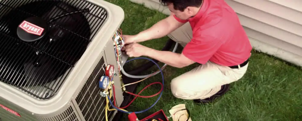 HVAC technician servicing an outdoor air conditioner unit in Burlington, VT