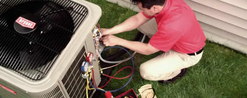 HVAC technician servicing an outdoor air conditioner unit in Burlington, VT